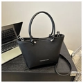 Detail of black leather bucket bag with knot handle and Fashion & Bag text on desk - Black