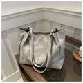 Détail du sac cabas gris texture marbre avec lanières en cuir et chaîne sur bois - Gris