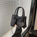 Chic black handbag with elegant satin bow accent and adjustable shoulder strap for women - Black