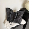 Bolso tote grande negro de diseño tejido minimalista con asas finas sobre fondo suave - Negro