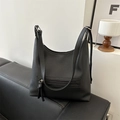 Black pebbled leather tote bag with front zipper pocket on a stylish sofa - Black