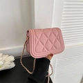 Pink quilted crossbody bag with gold chain strap shown being held in hand - Light Pink