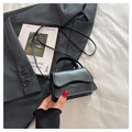 Detail of black mini crossbody bag with wavy flap design on grey suit and white fabric - Black