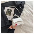 Detail of white wave pattern flap mini crossbody bag against a fashion suit backdrop - White