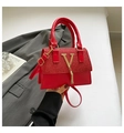Chic vibrant red handbag with gold V-buckle, fringe tassel and top handle detail - Red