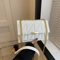 Elegant white quilted crossbody bag with gold chain strap and metal lock in a stylish setting - White