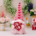 Rosa Valentinstag-Gnom mit gestrickter Herzmütze und funkelnder Pailletten-Schleife - Cupidos Pfeil