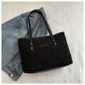 Detail of black corduroy tote bag with leather handles and gold rivet accents - Black