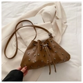 Brown drawstring bucket bag with silver metal studs on a cream blazer background - Brown