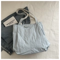 Vista plana del bolso tote plisado azul claro con parche FASHION sobre fondo blanco - Azul
