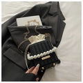 Detailansicht der schwarzen gewebten Eimertasche mit Perlengriff und goldener Kette - Schwarz