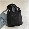 Detail van zwarte canvas shopper met modelabel en verstelbare schouderband - Zwart