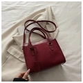 Detail of burgundy leather handbag with cylindrical handles on a stylish beige blazer - Red