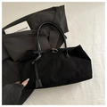 Détail d'un sac cabas en daim noir avec coutures fines et boucle dorée élégante - Noir