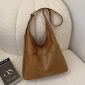 Borsa a spalla hobo marrone in ecopelle con tasca su un divano color crema - Marrone