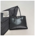 Vintage black leather tote bag with long handles in a minimalist aesthetic setting - Black