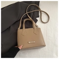 Close-up of khaki PU leather handbag with metallic 'FASHION' plate and adjustable strap - Dark Khaki