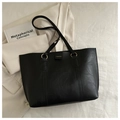 Detail of black faux leather tote bag with gold round buckle and fashion text branding - Black