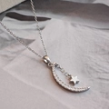 Collar minimalista de plata con colgante de estrella y luna en elegante fondo de seda - Color Acero