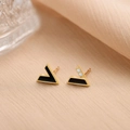 Détail de boucles d'oreilles asymétriques en V dorées avec émail noir et zircons - Boucles d'Oreilles Clous en V Couleur Or