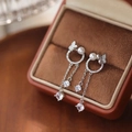 Silver butterfly pearl tassel earrings with micro-set zircons on brown velvet display - Pearl Butterfly Tassel Style