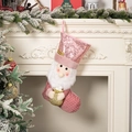 Calza di Natale rosa con paillettes e gnomo 3D appesa a un caminetto bianco - Babbo Natale