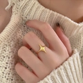 Anello aperto con stella polare dorata indossato con un maglione in maglia beige - Aperto Regolabile / Anello Stella - Oro / Oro