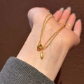 Französischer Gold-Tropfenanhänger mit doppelter Kette an der Hand des Modells - Ring Traan Halskette (Gold)