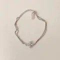 Detail eines S925 Sterlingsilber-Doppelarmbands mit einem zirkonbesetzten Kreuzanhänger - Doppellagiges Kreuzarmband