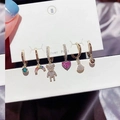 Detailed macro view of 6-piece gold hoop earring set with zircon charms on a display card - Bear Heart Rainbow Set