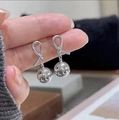 Macro detail van zilveren knoopoorbellen met gepolijste metalen bolhangers - Zilver