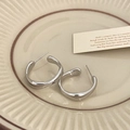 Detailansicht silberner minimalistischer Creolen auf einer Vintage Keramikplatte - Silber