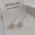 Close-up of elegant silver bow pearl drop earrings displayed on a jewelry card - Irregular Pearl Silver