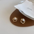 Detail of elegant gold twisted frame pearl earrings on a premium leather base - Hollow Twist Pearl