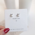 Detail of bow-shaped pearl stud earrings with sparkling zircons on a white display card - Zirconia Pearl Heart