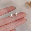 Detailed macro view of pearl stud earrings with V-shaped diamond-encrusted gold base - V-Shape Pearl