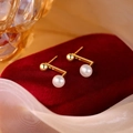 Macro shot of gold L-shaped pearl stud earrings on a luxury red velvet jewelry box - Pearl Metal Bean-Gold