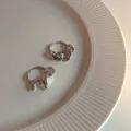 Orecchini a cerchio color argento con ciondoli circolari testurizzati su vassoio ceramico - Orecchini in argento a cerchi multipli