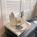 Borsa a spalla chic a mezzaluna beige con fibbia a farfalla e tracolla intrecciata - Bianco