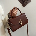 Retro deep brown leather shoulder bag with gold metal clasp shown with a stylish outfit - Dark Brown