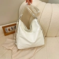 Bolso tote de cuero PU suave blanco crema con bolsillos frontales sobre un sofá - Blanco Roto