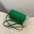Retro vibrant green cylindrical shoulder bag in premium PU leather on cozy sofa - Green