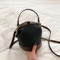 Bolso cubo chic en gris oscuro y marrón con herrajes dorados sobre tela blanca - Negro