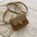 Vintage brown leather crossbody bag with elegant gold metal buckle on soft fabric background - Khaki
