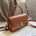 Retro caramel faux leather shoulder bag with gold clasp shown on a white table - Light Brown