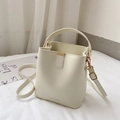Modern creamy white leather bucket bag with top handle, long strap and golden hardware - White