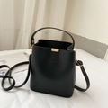 Minimalist black faux leather bucket bag with gold hardware and fashion lettering - Black