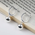 Minimalist silver spherical earrings on a vintage book page, polished mirror finish jewelry - Ball Pendant Ear Buckle