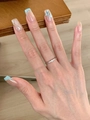 Nahaufnahme eines minimalistischen Silberrings mit fünf funkelnden Diamanten am Finger - Einstellbar Offen / Silber