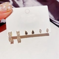 Close-up of golden earring set with zircon drops and studs on purple silk background - Waterdrop Zirconia Stud Earring Set